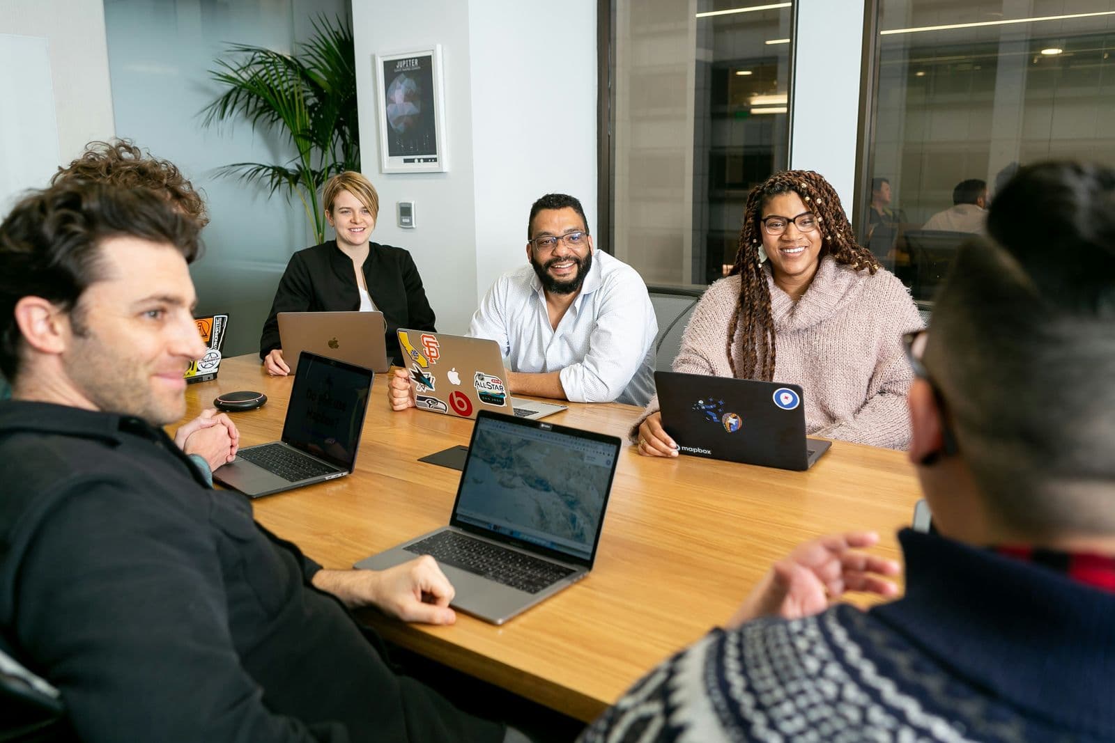 Team of four working on laptops during a board meeting