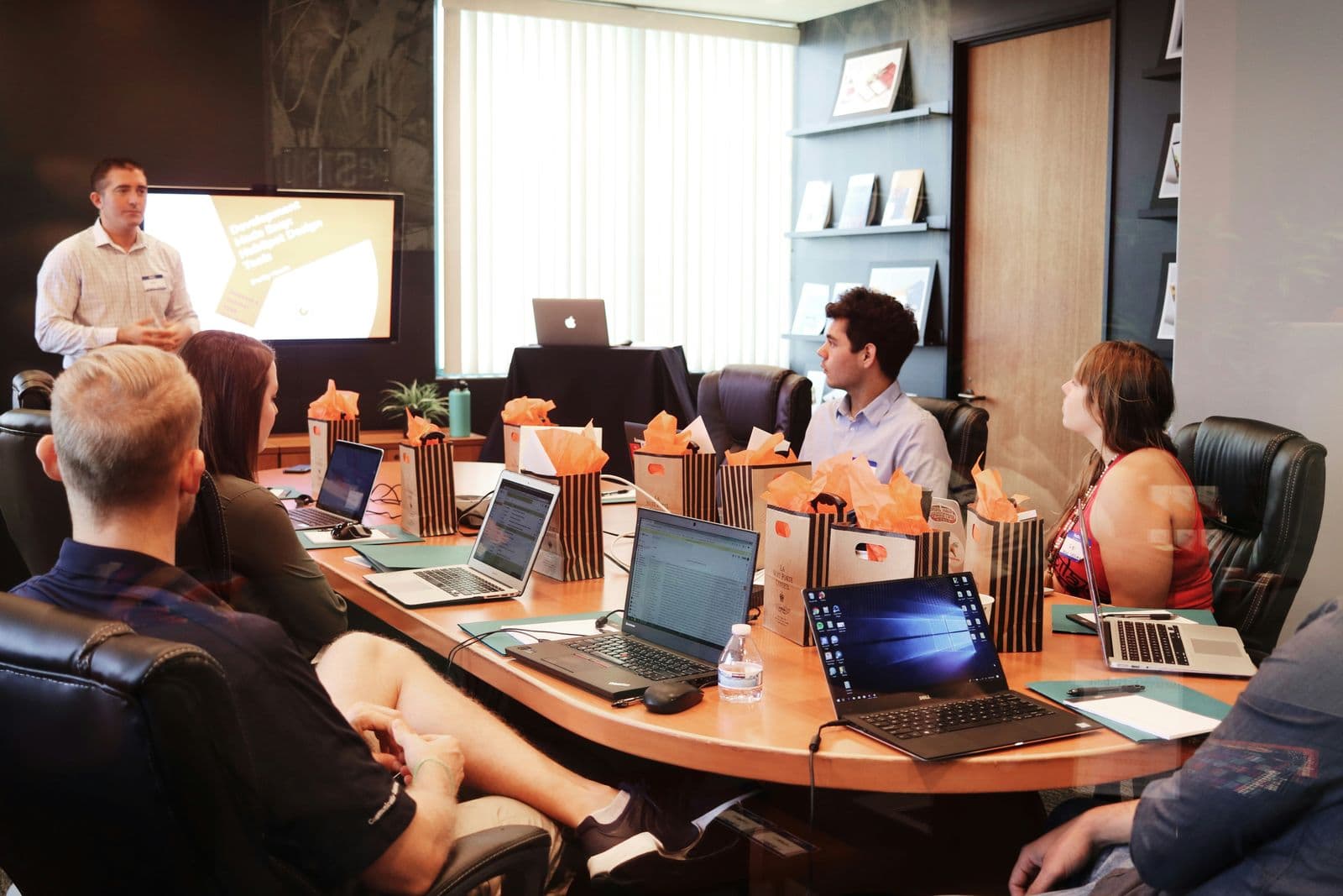 Consultant leading a business strategy session with a team working on laptops